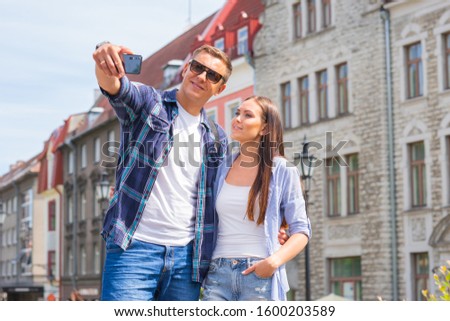 Couple of tourists traveling and exploring beautiful old town together. Loving man and woman in a vacation trip.