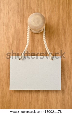 Paper signboard with rope hanging on a handle of door  