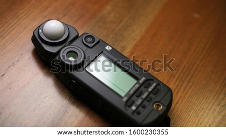light meter on wooden table. photography and cinema equipment
