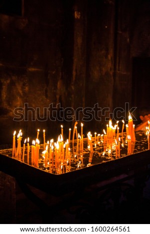 Burning candles in the church of Armenia. A candle burns in a vessel of water.