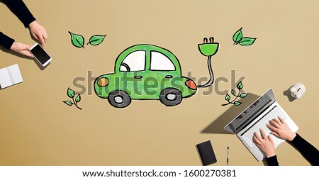 Electric car with people working together with laptop and phone