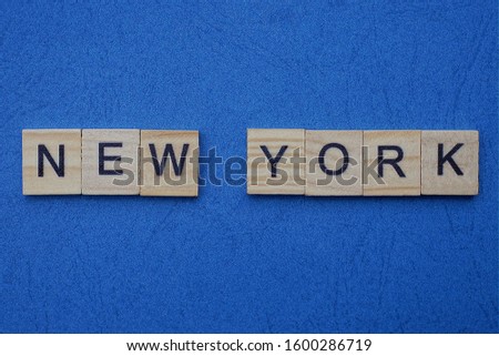 gray word new york from small wooden letters on a blue table