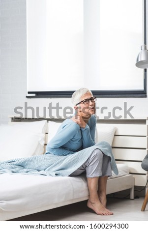 Senior woman suffering from shoulder pain, arthritis  and  numbness after sleep at home in bed. Old age, health problem and people concept