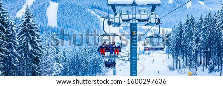 Skiers on chairlift at ski resort Royalty-Free Stock Photo #1600297636