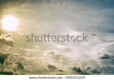 Paragliding sport - very golden sky with a silhouette of a person practicing paragliding flight
