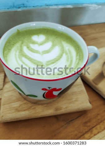 green tea latte in a cup. location at Sejiwa Coffee. North Lombok. West Nusa Tenggara. Indonesia. Photo taken in August 2019.  Royalty-Free Stock Photo #1600371283
