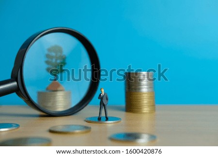 Miniature business concept - thinking businessman looking for financial solution