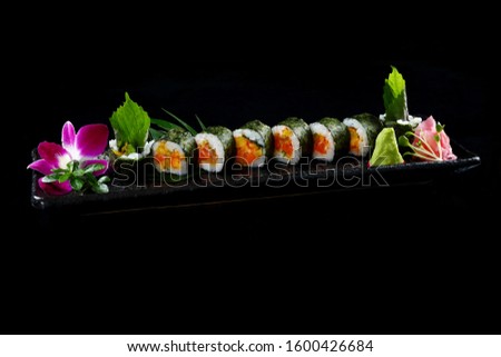 Spicy Salmon sushi roll on black ground
