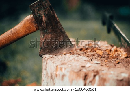 Axe stuck in the side of a wooden log