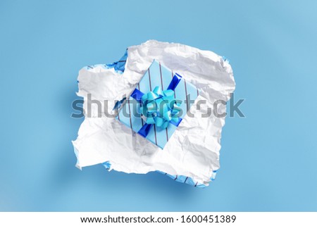 unwrapping present to find another layer of wrapping - Celebrations and events concept image with copy space for text. Royalty-Free Stock Photo #1600451389