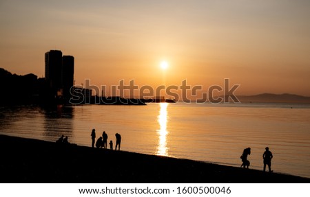 Silhouettes of people at sunset on the sea.
