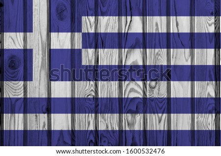 Greece flag depicted in bright paint colors on old wooden wall. Textured banner on rough background