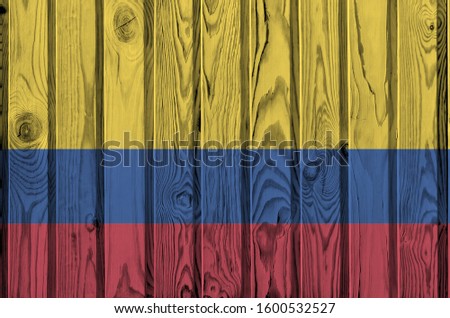Colombia flag depicted in bright paint colors on old wooden wall. Textured banner on rough background