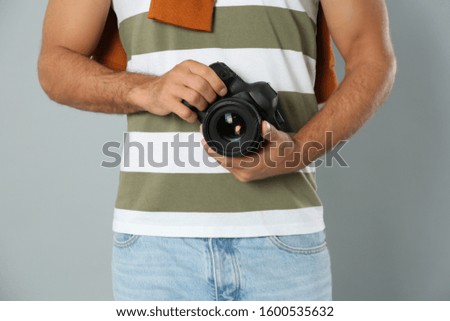 Professional photographer working on light grey background in studio, closeup