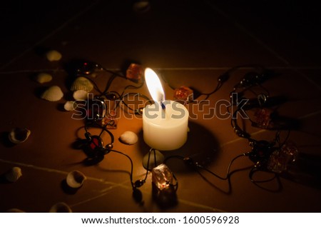 pentagram is painted on the floor, candles are lit, beads are lying, shells are scattered. concept of magic with occult and esoteric symbols.