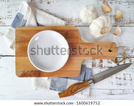 Cutting boards with empty plate and kitchen utensils are positioned in the middle from the top view.
