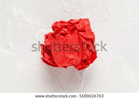 red crumpled paper ball on a light background. Idea concept.