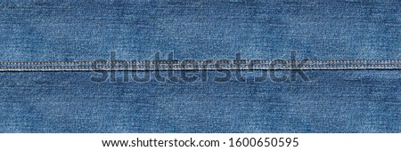 flat lay, denim jeans leg seam detail, background texture, copy space Royalty-Free Stock Photo #1600650595