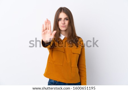 Young woman over isolated white background making stop gesture