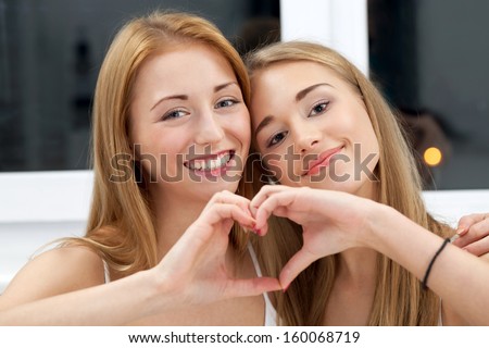 Two best friends showing their common heart Royalty-Free Stock Photo #160068719