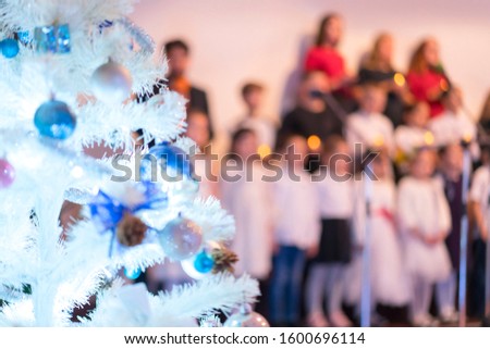 Children's New Year's Choir. Christmas tree and children's choir. Christmas and New Year concept. Blurry