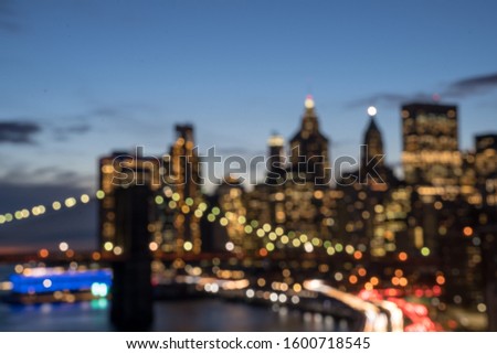 Blur background of New York City Skyline aerial view from Manhattan Bridge with skyscrapers background at dusk. Financial District of NYC with traffic light trails on FDR Drive