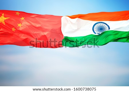 Chinese and Indian flags amid blue skies