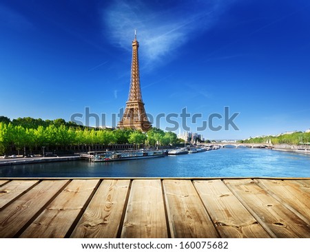 background with wooden deck table and Eiffel tower in Paris 
