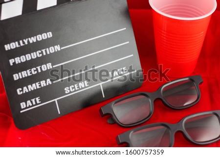 Open movie black clapper board isolated on colored background. Movie, cinema, film making industry equipment, 3D glasses.