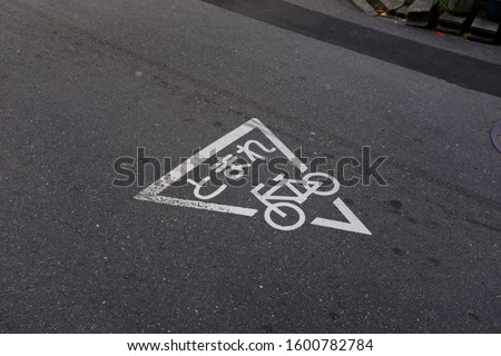 Japanese bicycle road signage - stop sign in hiragana for cyclists and bikes, white paint on asphalt in Japan, tomare means stop
