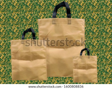 Three size non woven bags with leaves background