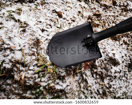 Attempt to dig a hole with a sapper shovel in the frozen ground, Russia 