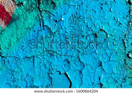 Fragment of colored graffiti with peeling paint on a wall. Bright abstract background for design.