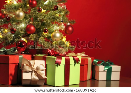 Christmas tree with gifts on red background.