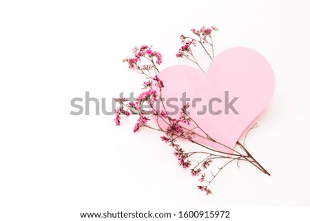 A large pink heart with a place for text decorated with small pink flowers on a white background, symbol of love