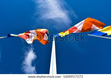 Waving colorful Buddhist Flags in cloudy blue sky background 