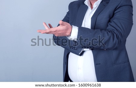 Business man with pointing to something or touching a touch screen on grey background

