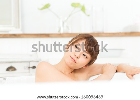 Beautiful asian woman relaxing in the bathroom