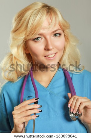 Closeup portrait of a female doctor with stethoscope, isolated on grey background