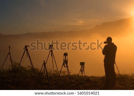 Unknown photographer in silhouette during misty sunrise in Sabah Borneo