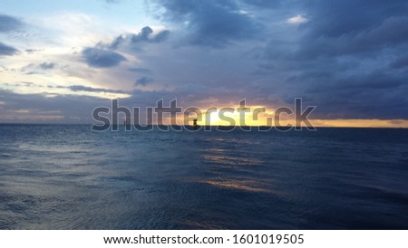 Unworthy windmills at sea at dawn  Royalty-Free Stock Photo #1601019505