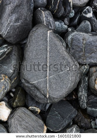 Grey rocks with the cross sign on them on vulcanic surface near Franz Josef Glacier in New Zealand