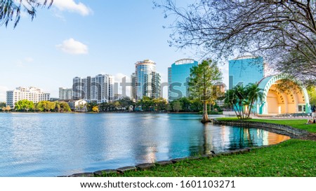 Peaceful Lake Eola Park in downtown Orlando, Florida. Muet swans glide in the glistening waters of Lake Eola Park a popular destination in Orlando, Florida.