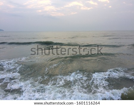 Blue ocean waves splitting into spiral bubbles Isolated on the morning sky background Natural climate concepts Viewed from the front.