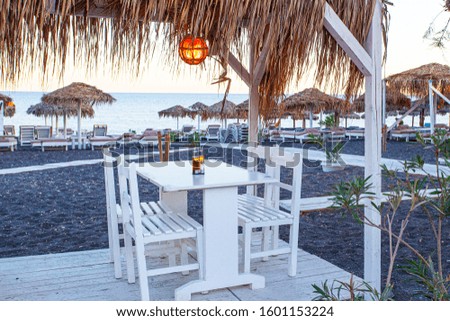 Tables near the Perissa beach in cafe, Santorini island, Greece