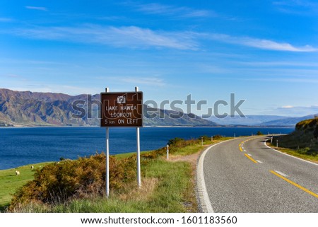 Scenic road next to the Hawea lake surrounded by mountains in New Zealand