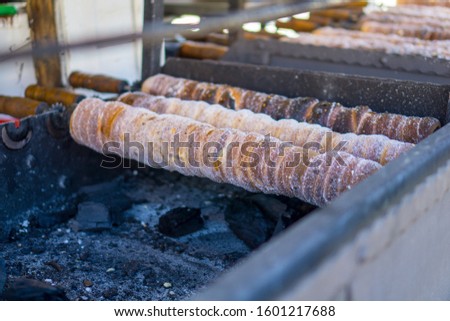 Picture of Trdelnik being grilled. Trdelnik is a popular Prague pastry made from rolled dough wrapped around a stick, that is normally grilled and topped with sugar. 