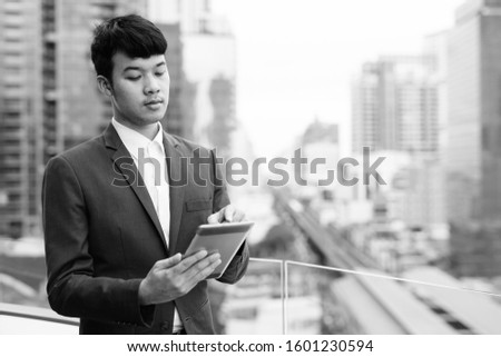 Young Asian businessman against view of the city