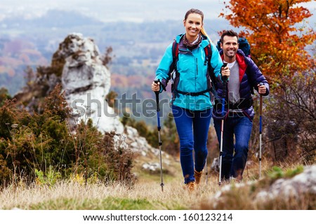 Fall. Couple Backpackers hiking on the path in mountains during autumn. Royalty-Free Stock Photo #160123214