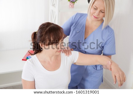 Female patient and doctor have consultation in hospital. Picture of middle aged woman during rehabilitation in professional clinic. Closeup